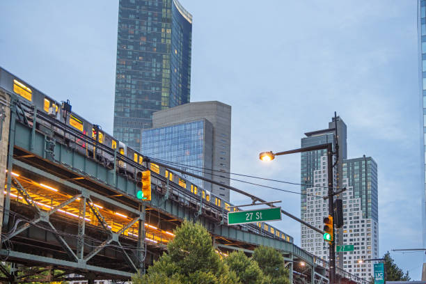 Queensboro Plaza Station, Long Island City, Queens, New York, USA - August 12th 2023:  High rise subway train and station at dusk