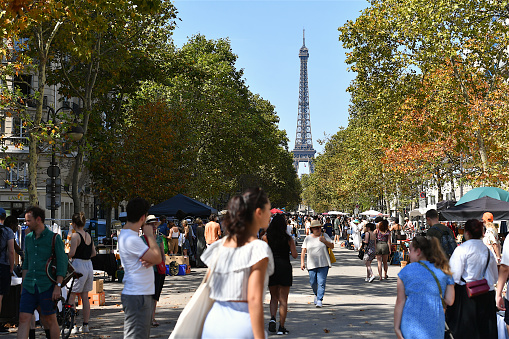 Paris, France - July 18, 2017: Lot of people enjoying day and relaxing on Trocadero square and garden with Eiffel Tower in background. Sunny evening just before sunset.