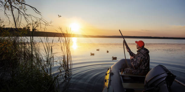istock Duck hunter at sunrise. Waterfowl hunter in boat at sunset. banner with copy space. 1680206991
