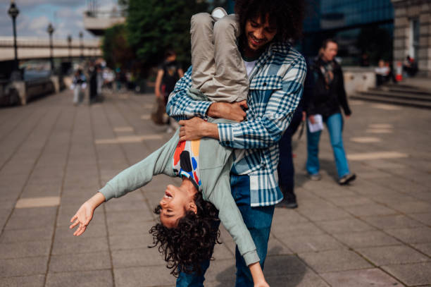 istock A father playfully holds his son upside down 1680221381