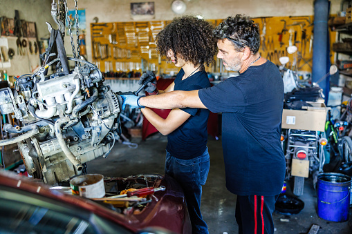 Man teaches his son car mechanics
