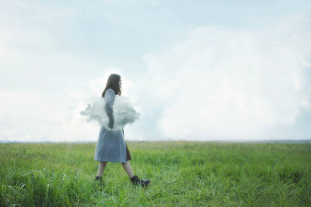 istock woman walking under her arm a cloud in a field, abstract concept 1680253355
