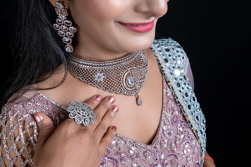 Close-up portrait of Beautiful young female model wearing diamond necklace and earing , Elegant Woman in Necklace with Earring and Finger Ring.