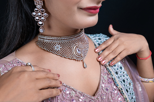 Close-up portrait of Beautiful young female model wearing diamond necklace and earing , Elegant Woman in Necklace with Earring and Finger Ring.