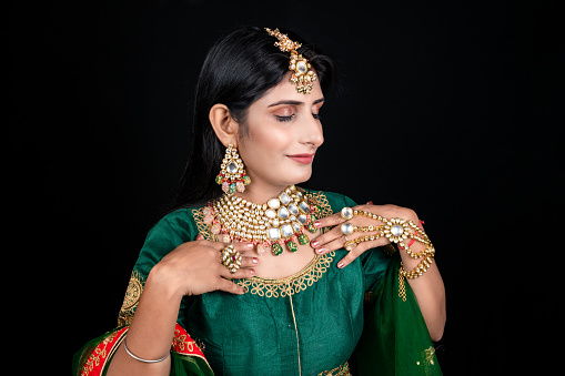 Closeup shot of young female model wearing Gold and diamond - gemstone wedding necklace with earing