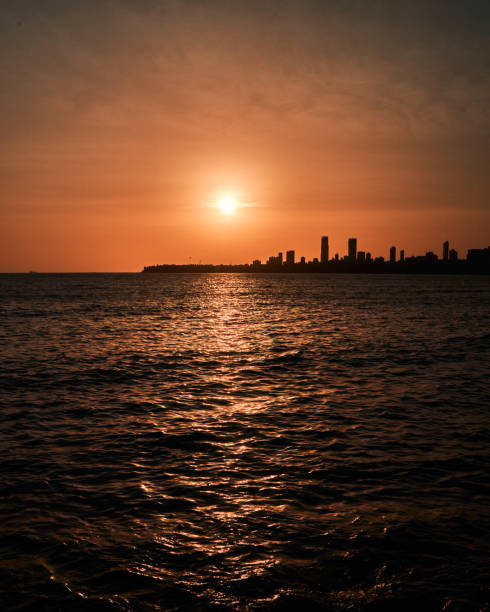 istock Sunset at Sea shore with rocks and Skyscrapers. 1680284207