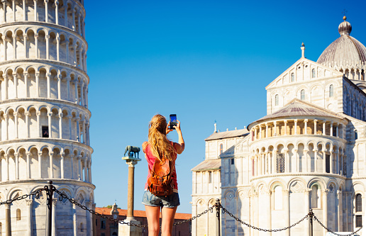 Selfie portrait of young couple in Rome enjoying travel in Italy and capturing  a photo in front of the famous Colosseum; People travel capital in Europe concept