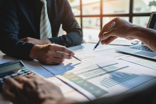 trabalho em equipe com análise de pessoas de negócios gráfico de custos na mesa na sala de reuniões. a equipe de negócios discutiu reuniões e estratégias de briefing. negociação, análise, discussão - financial graph - fotografias e filmes do acervo