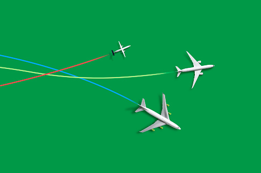 Passenger aircraft with contrails on green background