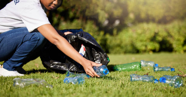 faites du bénévolat, des mains et du plastique ou des déchets dans un parc, des services communautaires et du recyclage pour le changement climatique ou le projet du jour de la terre. personne bénévole à l’extérieur ou au jardin pour le nettoyage  - bag garbage bag plastic black photos et images de collection