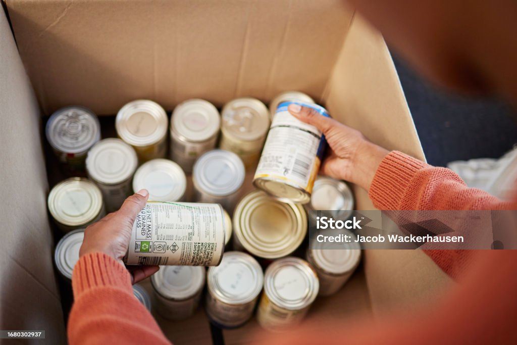 Donation, food in cans in box and hands of man checking stock, decision and volunteer with ngo help. Support with charity, choice and refugee at grocery distribution for sustainable community service Food Stock Photo