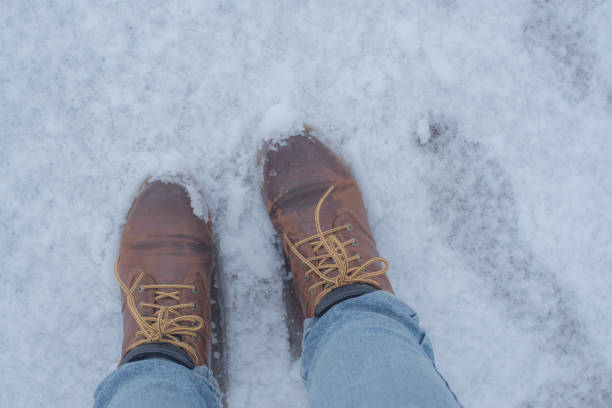 istock brown boots on the snowy road 1680305695