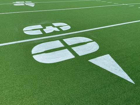 Close-up of a freshly-painted white 30-yard line with the 40-yard line behind it on the outdoor green astro-turf football field at Denny Farrell Riverbank State Park in West Harlem, New York City