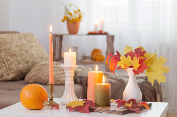 istock burning candles with autumn decor on white table at home 1680314027