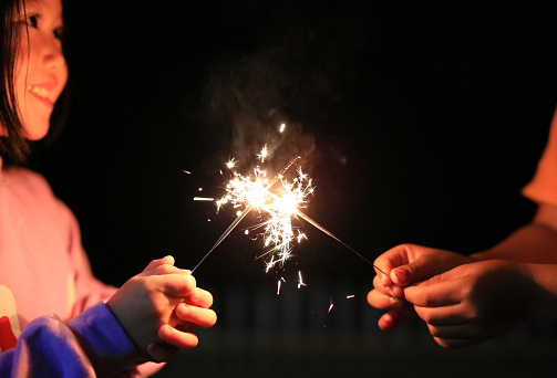 Children are playing with fire sparklers on the festival.