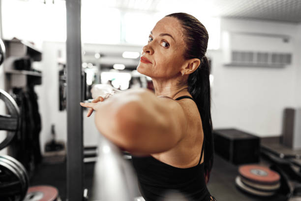istock Fit woman doing squats with barbell in a gym 1680321498