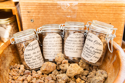 In Winter Garden, United States at the Saturday Farmer’s Market myrrh resin used for medicinal purposes and burning as incense is displayed for sale in glass jars.