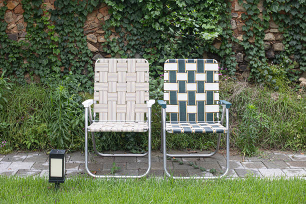 Recreation and tourism advertising. Empty brown wooden deck chair or chaise longue, on the green grass of a fresh lawn. Place for text