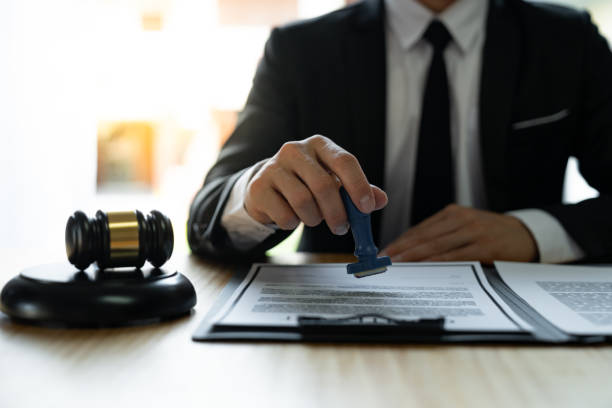 istock Young Asian legal advisor or lawyer doing document approval stamp Business agreements regarding real estate financial documents at the office. 1680347541