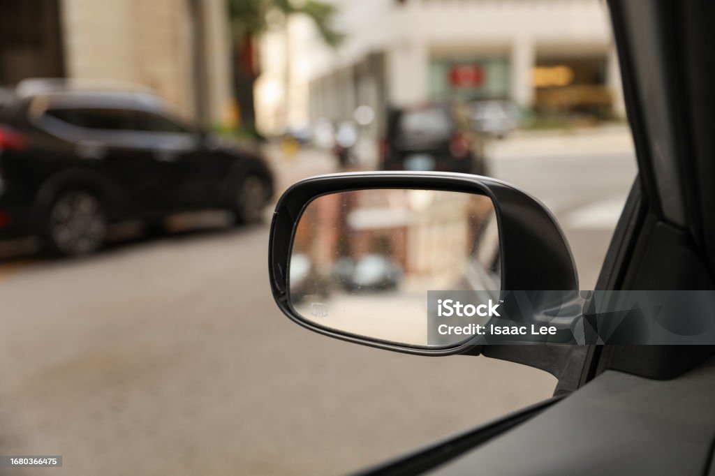 car's rearview mirror, reflecting a scenic road behind. The mirror symbolizes nostalgia, reflection, and the journey of life, capturing moments from the past Car Stock Photo