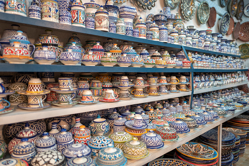 Handmade ceramic tea cups and tea cans of various patterns and colors on shelves, Fez, Morocco.