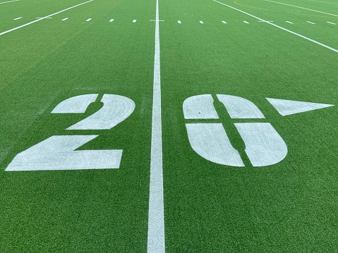 Close-up of a freshly-painted white 20-yard line on the outdoor green astro-turf football field at Denny Farrell Riverbank State Park in West Harlem, New York, NY