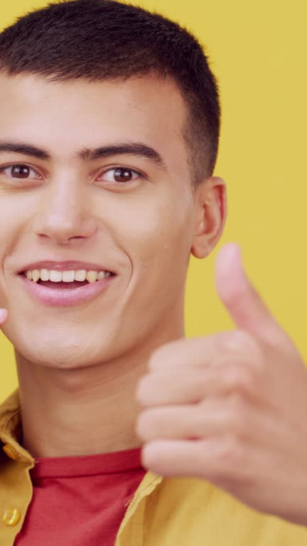 Thumbs up, call me and portrait of a man in studio with communication and connection. Face of young male student person from France with phone emoji, hand sign and contact info on a yellow background