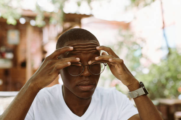 tired interracial dark skin man in eyeglasses touching and rubbing his eyes, feeling pain. vision problem - human eye tired rubbing businessman imagens e fotografias de stock