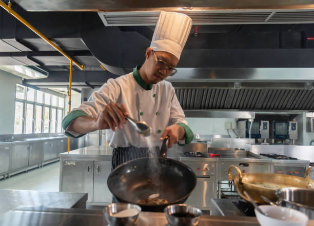 istock hef in the professional kitchen with a frying pan and a fire. Chef's hands hold iron Pan 1680465641