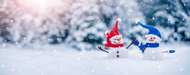 Little snowmen on the white snow on blue background. Beautiful panoramic view.