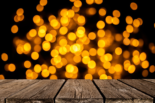 Empty wooden table with defocused Christmas lights background