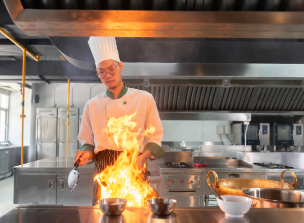 istock hef in the professional kitchen with a frying pan and a fire. Chef's hands hold iron Pan 1680469891