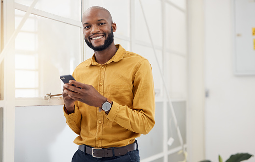 Happy black man, portrait and typing on smartphone in office for social media, networking and mobile contact. Business employee with phone, reading tech notification and information with digital chat