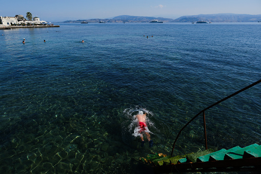 Elderly people enjoy the sunny weather as they swim in the sea of Corfu, Greece on September 2, 2023.