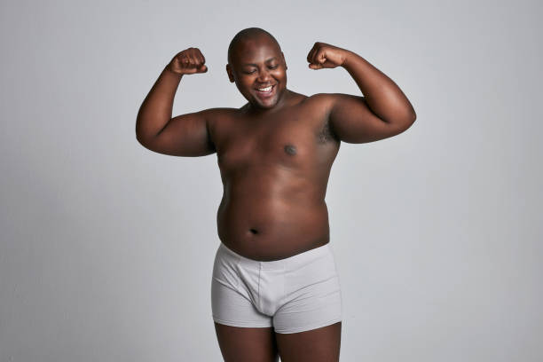 Strong man in underwear, plus size and body positivity with health, fitness with inclusion on white background . Shirtless, muscle and mockup space, confidence and African with wellness in studio Strong man in underwear, plus size and body positivity with health, fitness with inclusion on white background . Shirtless, muscle and mockup space, confidence and African with wellness in studio fat guy no shirt stock pictures, royalty-free photos & images