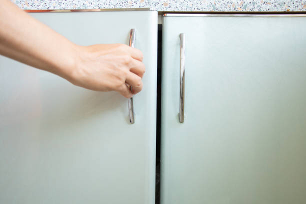 istock Woman's hand opens kitchen cabinet under sunlight, kitchen furniture 1680502943
