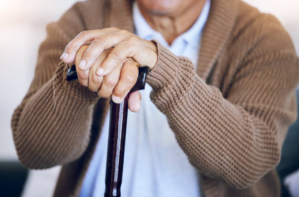 istock Hands, walking stick and senior person with a disability in nursing home for mobility support, help and balance closeup. Elderly patient, fingers and cane in house living room or arthritis healthcare 1680503977