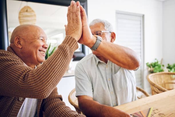 jogo sênior, feliz e homens com um high five para o sucesso, motivação ou uma vitória. sorrir, juntos e idosos com um gesto de mão para apoio, objetivo ou confiança em um lar de idosos com solidariedade - comunidade de aposentados - fotografias e filmes do acervo