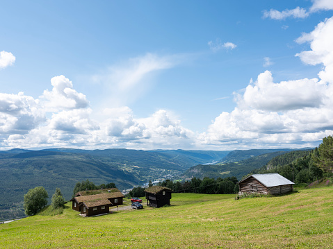 mountain landscape and huts near lillehammer in norway with green grass roofs and valley in the distance