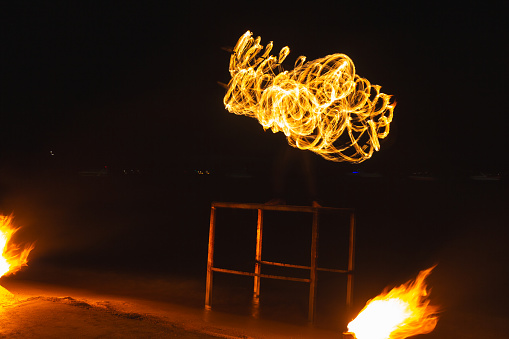 Krabi, Thailand - March 08, 2023: Tourists are watching and enjoying the fire dancer show at Ao Nang beach in Krabi, Thailand