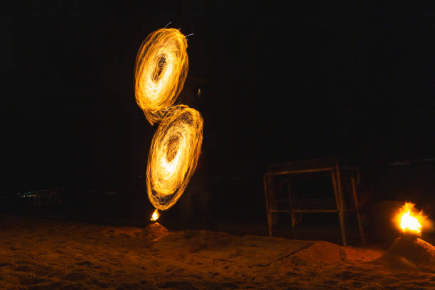 Fire dancers fire dancing show. Fire show on the beach. Dancing man juggling fire. Koh Samui, Thailand. Fire performance at night.
