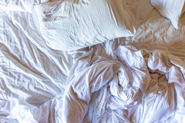 istock Top view of unmade bedding sheets and pillow, wrinkled bedding 1680556589