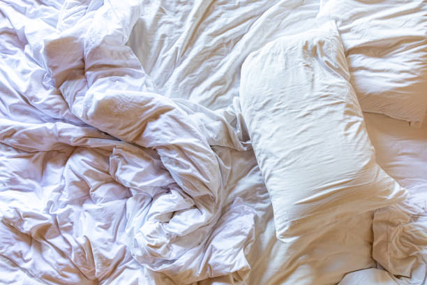 istock Top view of unmade bedding sheets and pillow, wrinkled bedding 1680556596