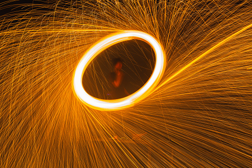 Long exposure shot of the Fire dancers fire dancing show. Fire show on the beach. Dancing man juggling fire. Koh Samui, Thailand. Fire performance at night.