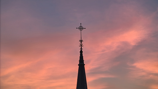 The silhouette of the cross and church bell tower in sunrise, sunset time. Aerial shot. High quality photo