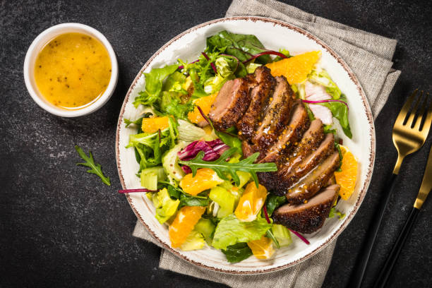 istock Salad with baked duck, green salad mix and oranges. 1680672099