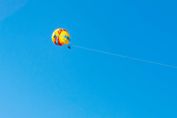istock parasailing. ride on a colored parachute attached to a motor boat. place for text 1680695929