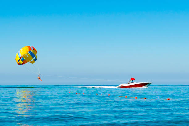 istock parasailing. ride on a colored parachute attached to a motor boat. place for text 1680695932