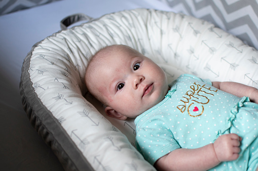 4 months old Caucasian cute baby girl in a crib. Infant girl. Newborn baby. Baby care