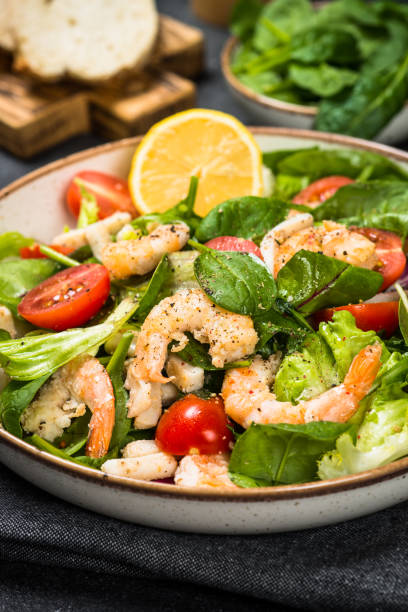 istock Shrimp salad with green leaves at stone table. 1680717392